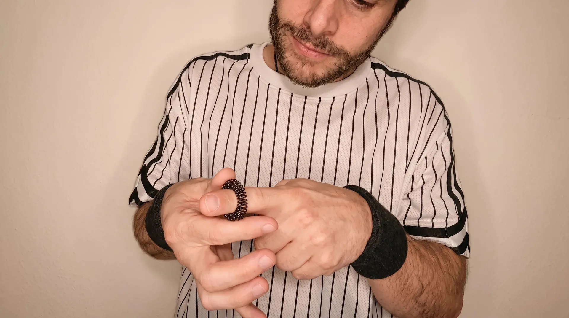Luka im gestreiften Shirt rollt einen Igel-Massagering über den Finger